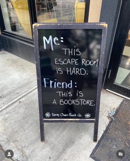 A chalkboard outside an establishment of some sort.
It reads as follows
Me, "This escape room is hard. Friend, "This is a bookstore"