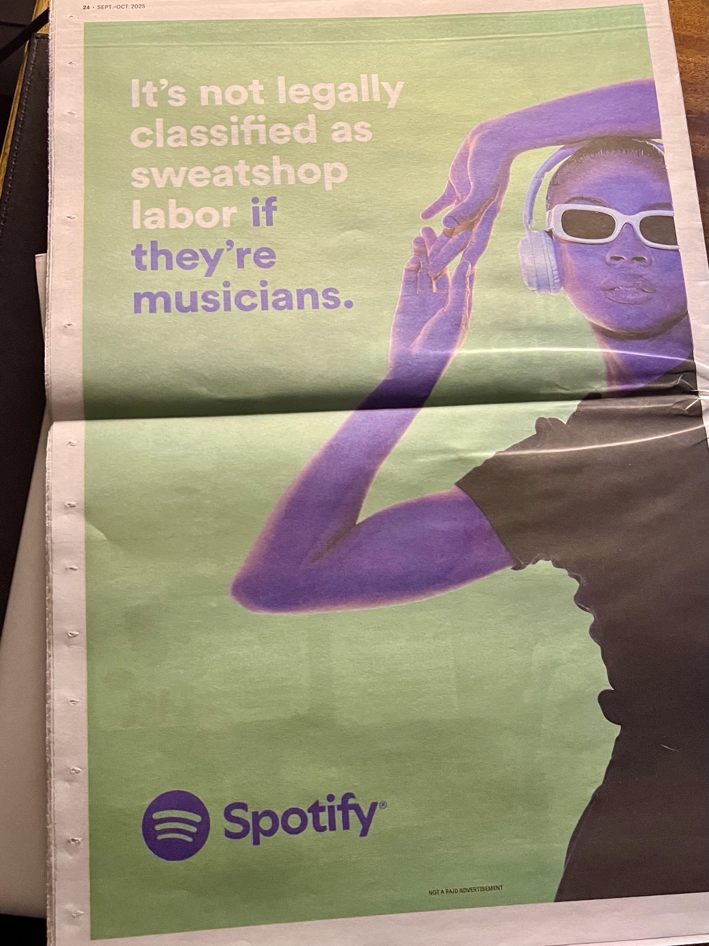 A colorful advertisement featuring a figure wearing headphones and sunglasses, alongside the text: “It’s not legally classified as sweatshop labor if they’re musicians.” The Spotify logo is displayed at the bottom.