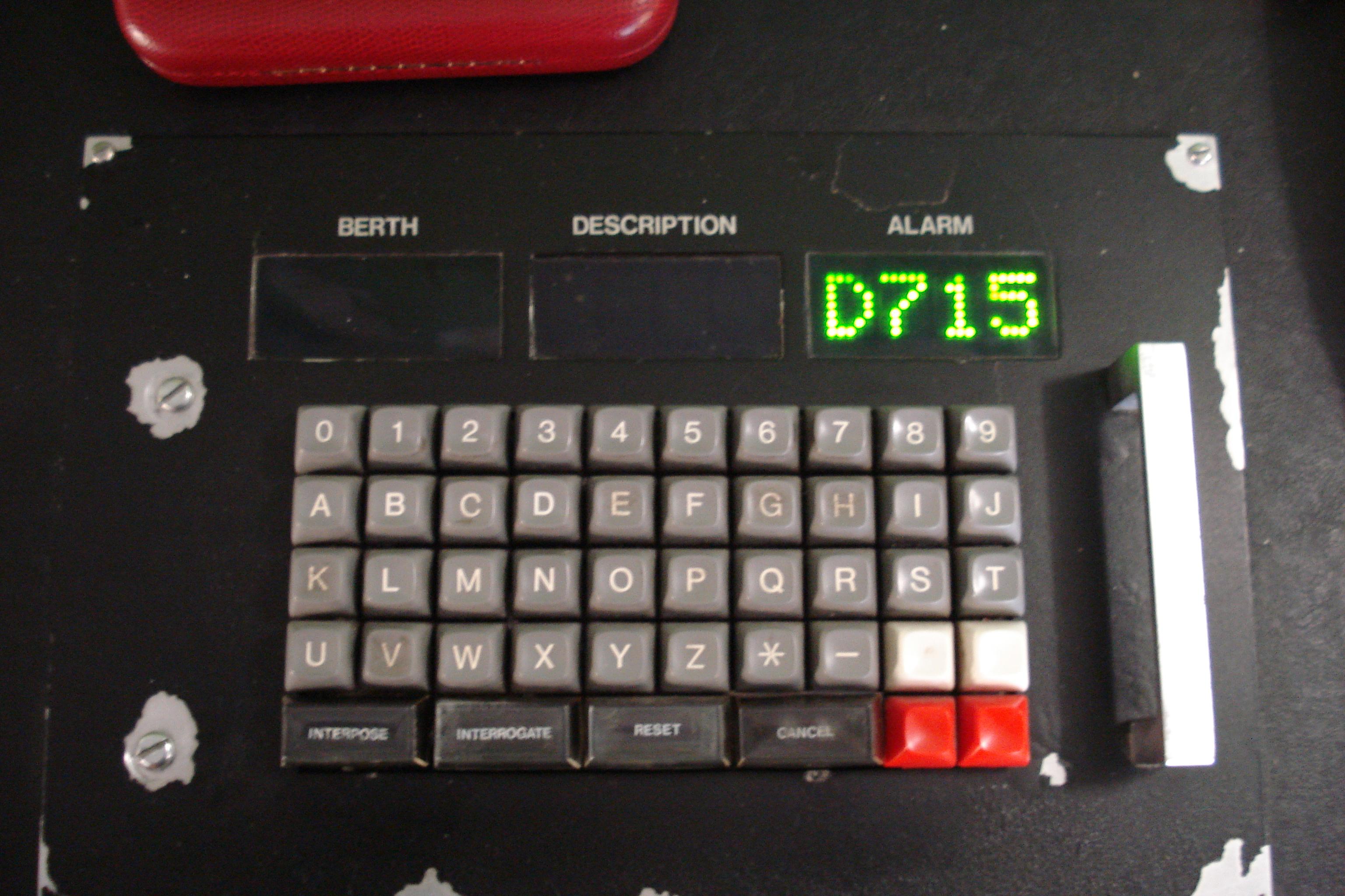 the Train Describer Control Unit that was part of Dundee signalbox from 1985-2021. there are three four-character LED matrix displays labelled Berth, Description, Alarm. then a 10x5 alphanumeric keyboard with the letters in alphabetical order and special keys Interpose, Interrogate, Reset, Cancel