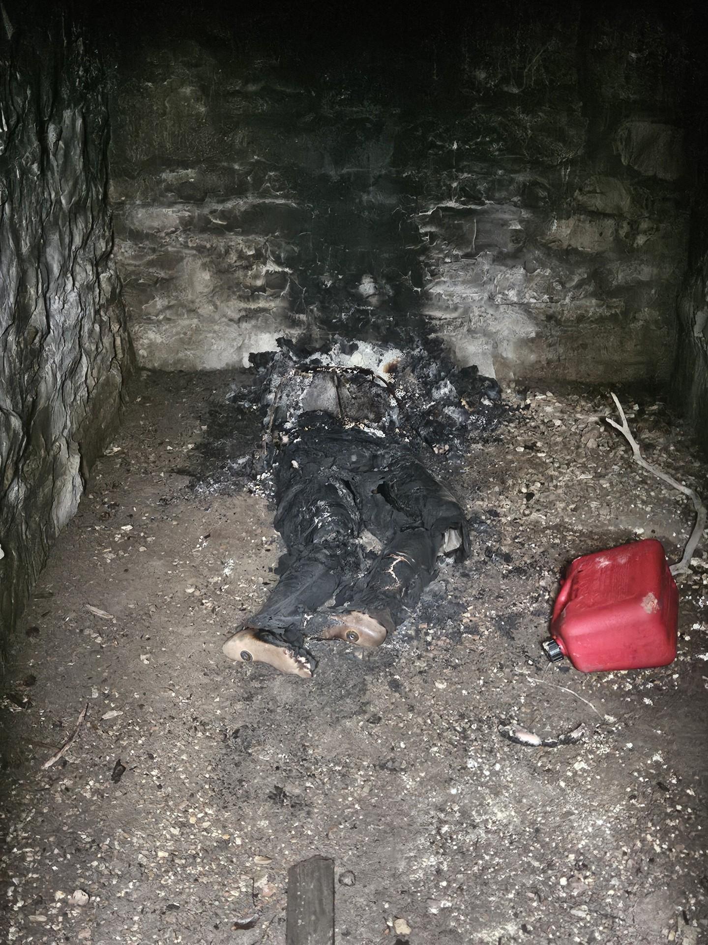 A close up of the burnt body, it's very charred, you can tell it's a body mostly because of the vague shape and the feel sticking out mostly unburnt