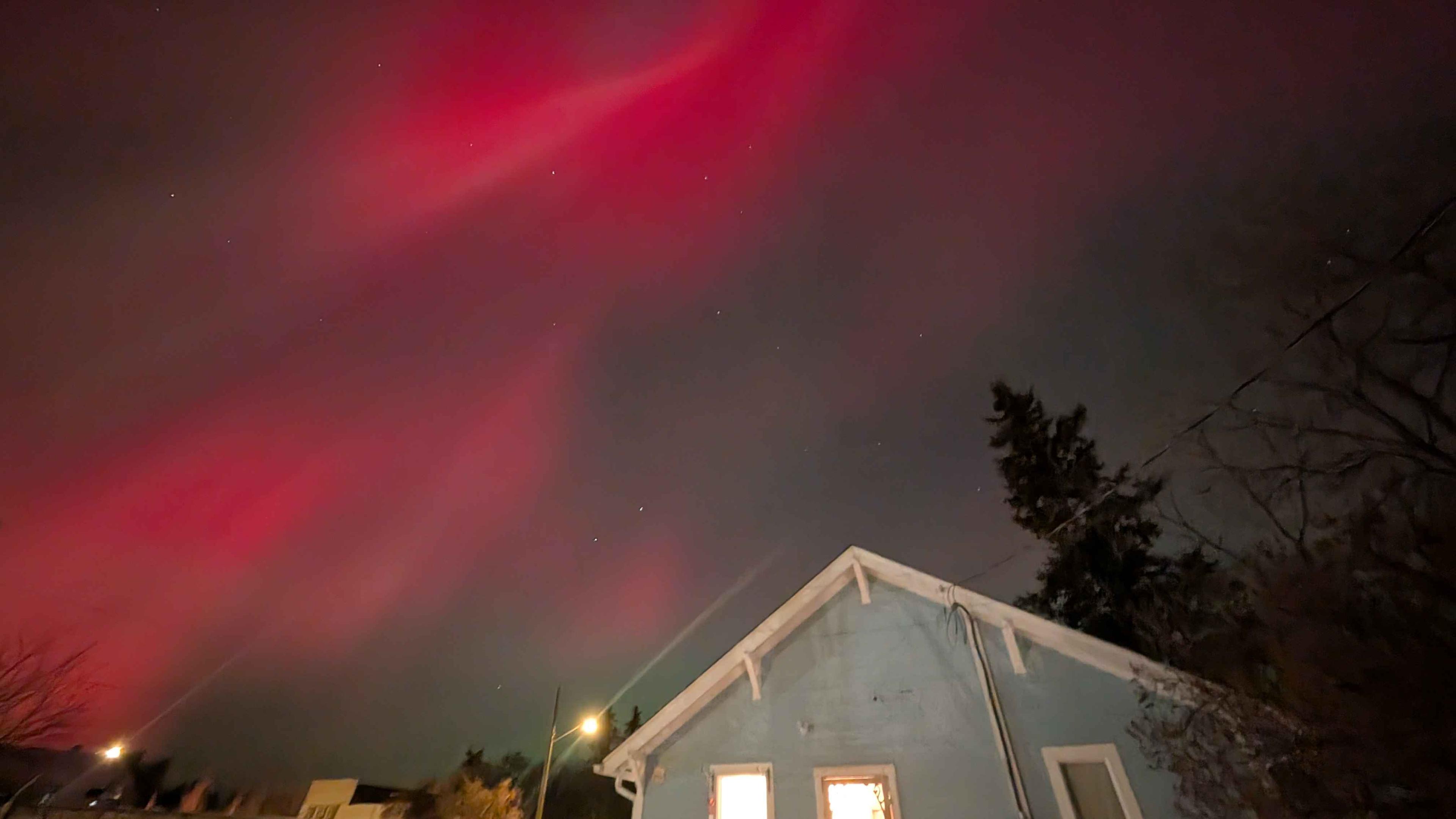 Red aurora borealis over a blue and White House.