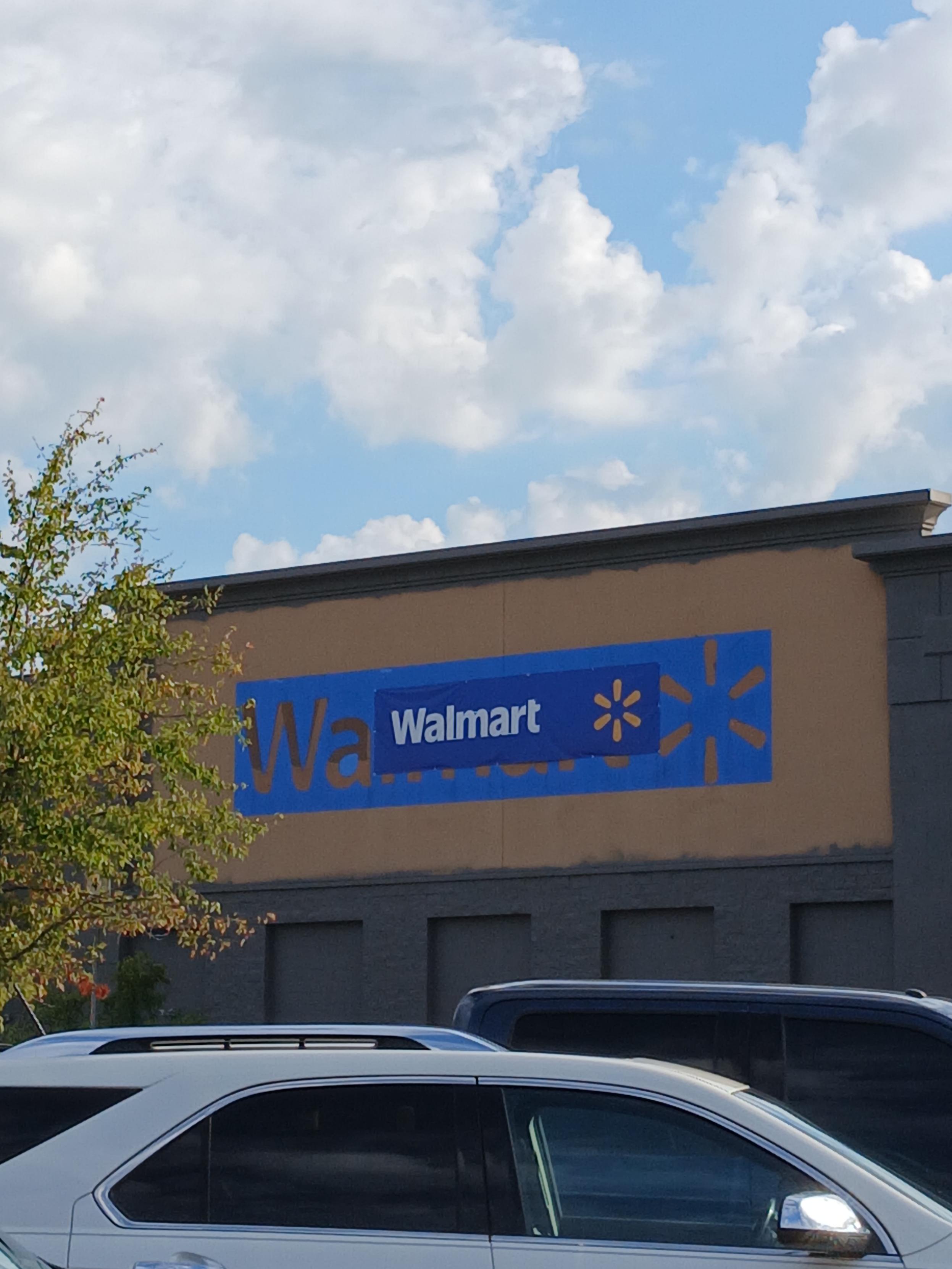 A large Walmart sign at my local Walmart with a small canvas sign tied over it that looks nearly identical