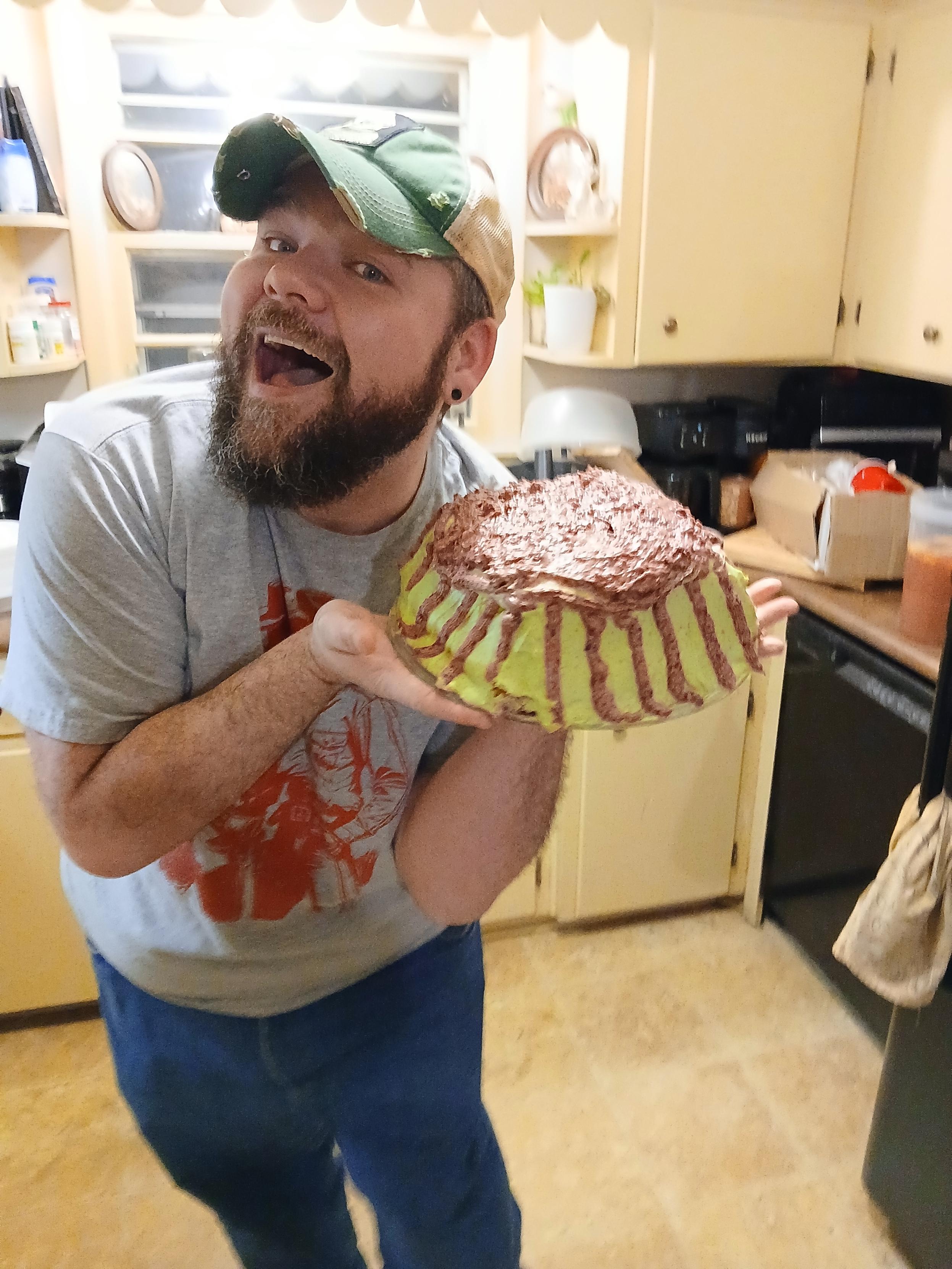 My brother holding his Cake Wreck like an Instagram Girlie. To the side, half bent over with a huge open mouth smile
