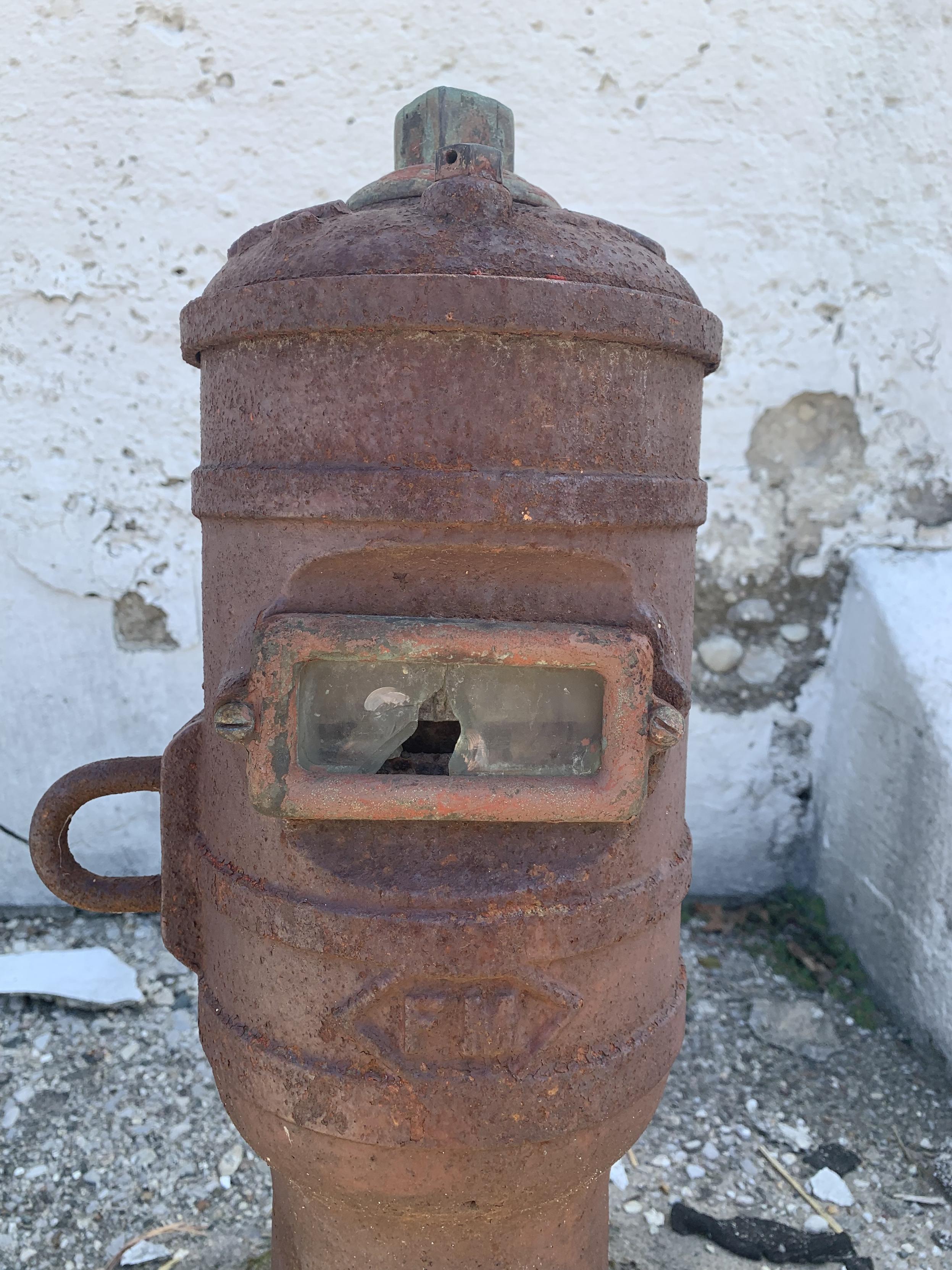 rusty metal fire-hydrant looking thing with horizontal glass door, glass cracked — what is this thing?