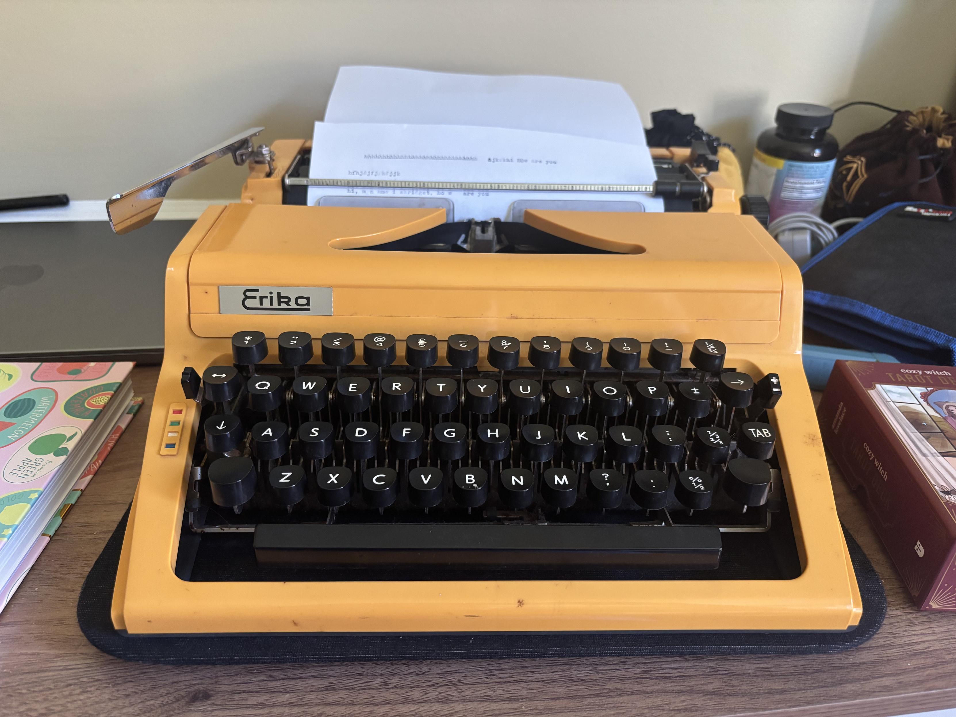 A yellow mechanical typewriter with the word Erika on it
