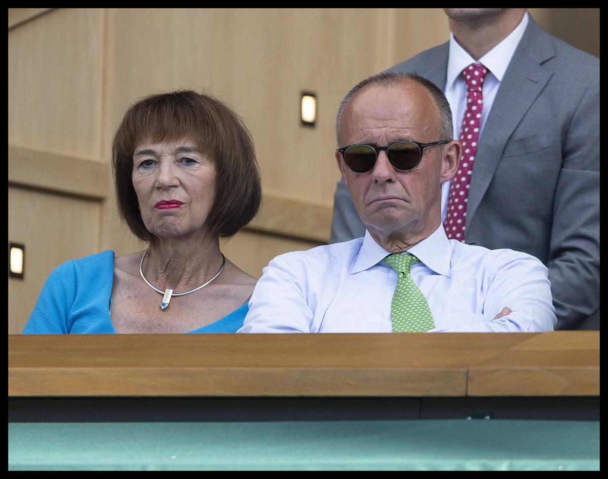 Friedrich Merz rechts neben seiner Frau, schlechte Stimmung verbreitend.