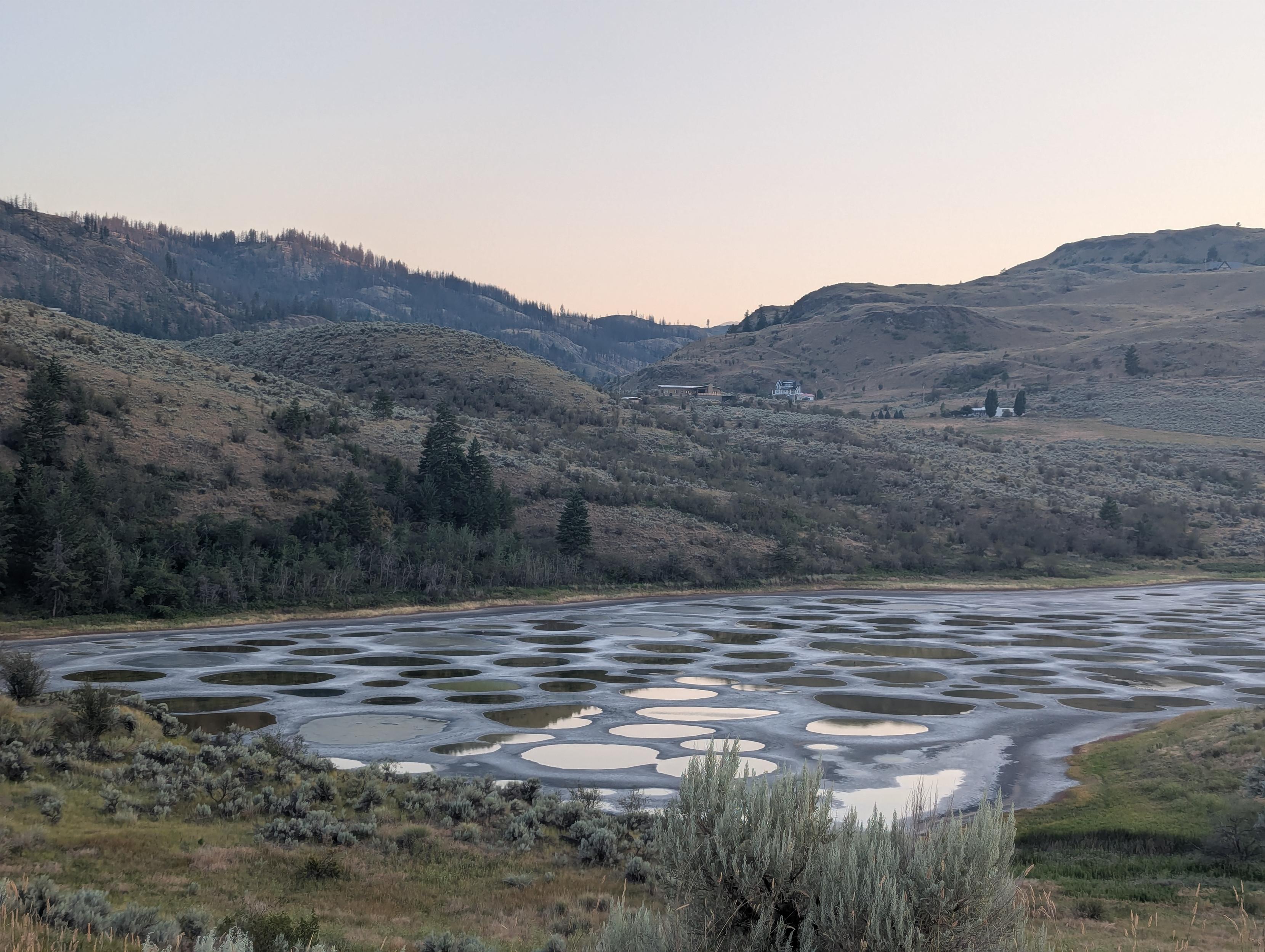 The spotted lake at sunset. The light is reflected where it's not blocked by the mountains' shadows. The circles in the mud look surreal.