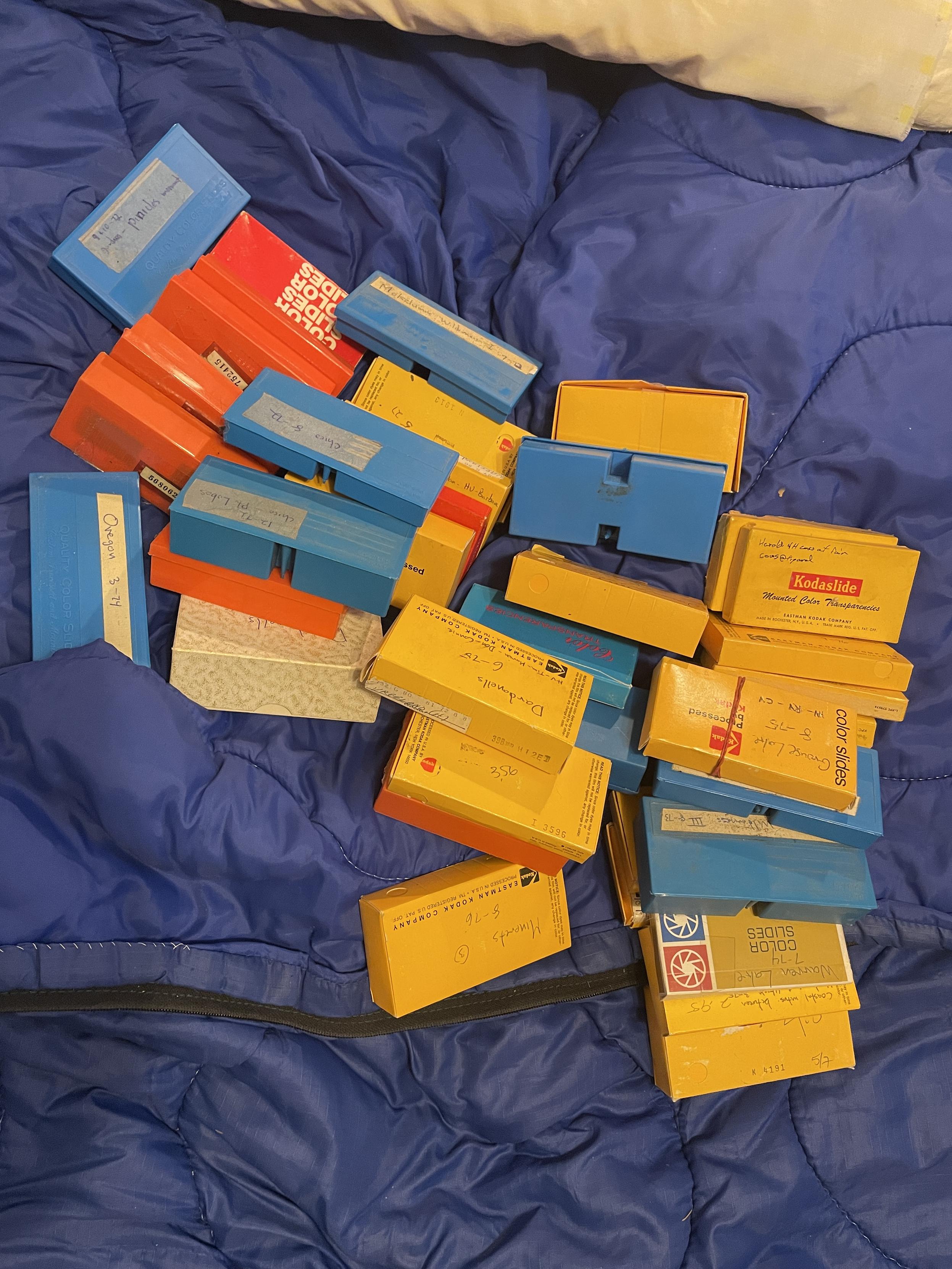 A disorganized jumble of small boxes full of 35mm color transparencies.