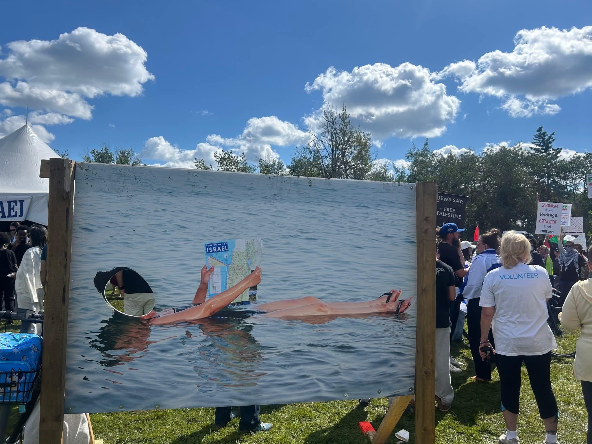 Photo cut out board at Israel pavillion at Heritage Days has you putting your face in the place of a tourist in "Greater Israel" relaxing in the sea with a map of Israel which includes all of Gaza and West Bank. Photo credit to my friend Jay Smith.
