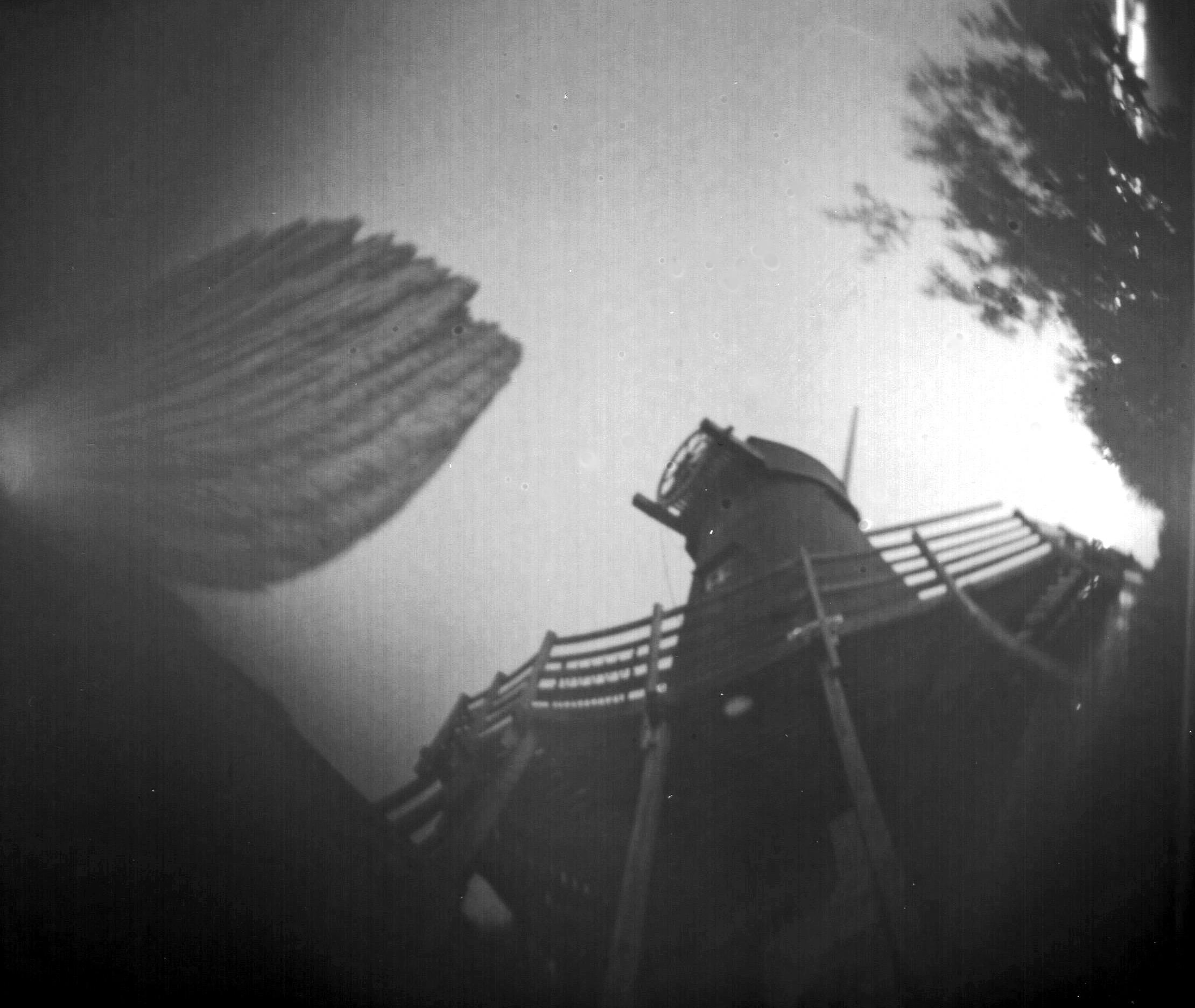 A black and white image from the bottom of the windmill looking up